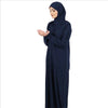 Una mujer vistiendo una elegante kaftan de abaya islámica azul marino con hijab.