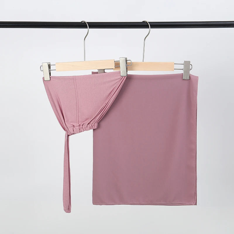 Mauve Chiffon-Hijab und Unterkleid-Set an einem Holzbügel hängend.