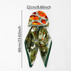 An orange and green floral satin silk instant hijab scarf displayed against a white background.