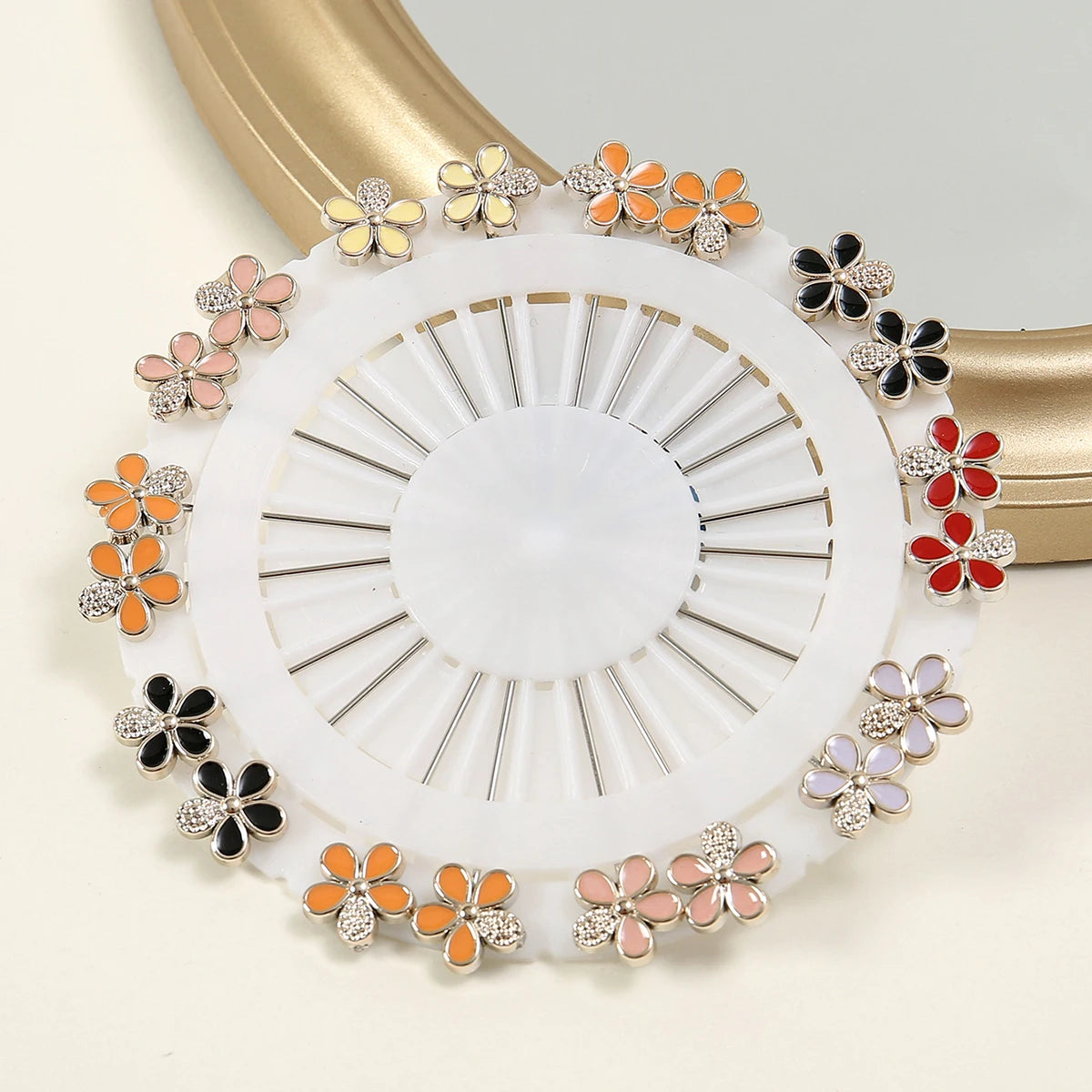Un juego de alfileres para hijab de seda con patrones de mariposas en tonos naranja, rosa y blanco sobre una base circular bl