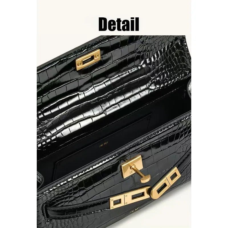 A close-up detail shot of a black crocodile pattern shoulder bag with gold hardware.
