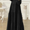 Eine Frau in einem eleganten schwarzen muslimischen Abaya-Kaftan-Kleid mit langen Ärmeln und vollem Rock.