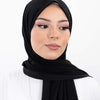 Une femme portant un hijab instant en mousseline noire avec des vêtements blancs.