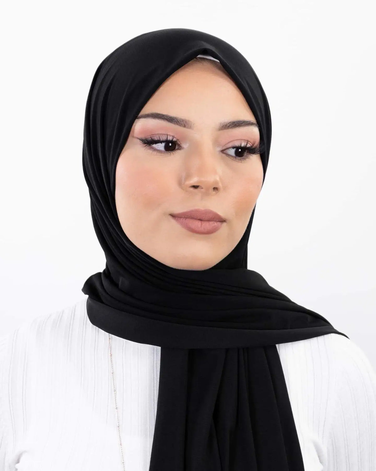 Une femme portant un hijab instant en mousseline noire avec des vêtements blancs.