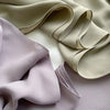Nahaufnahme eines Premium-Hijab-Sets aus zartem Lila und Beige, das die drapierte Stoffqualität zeigt.