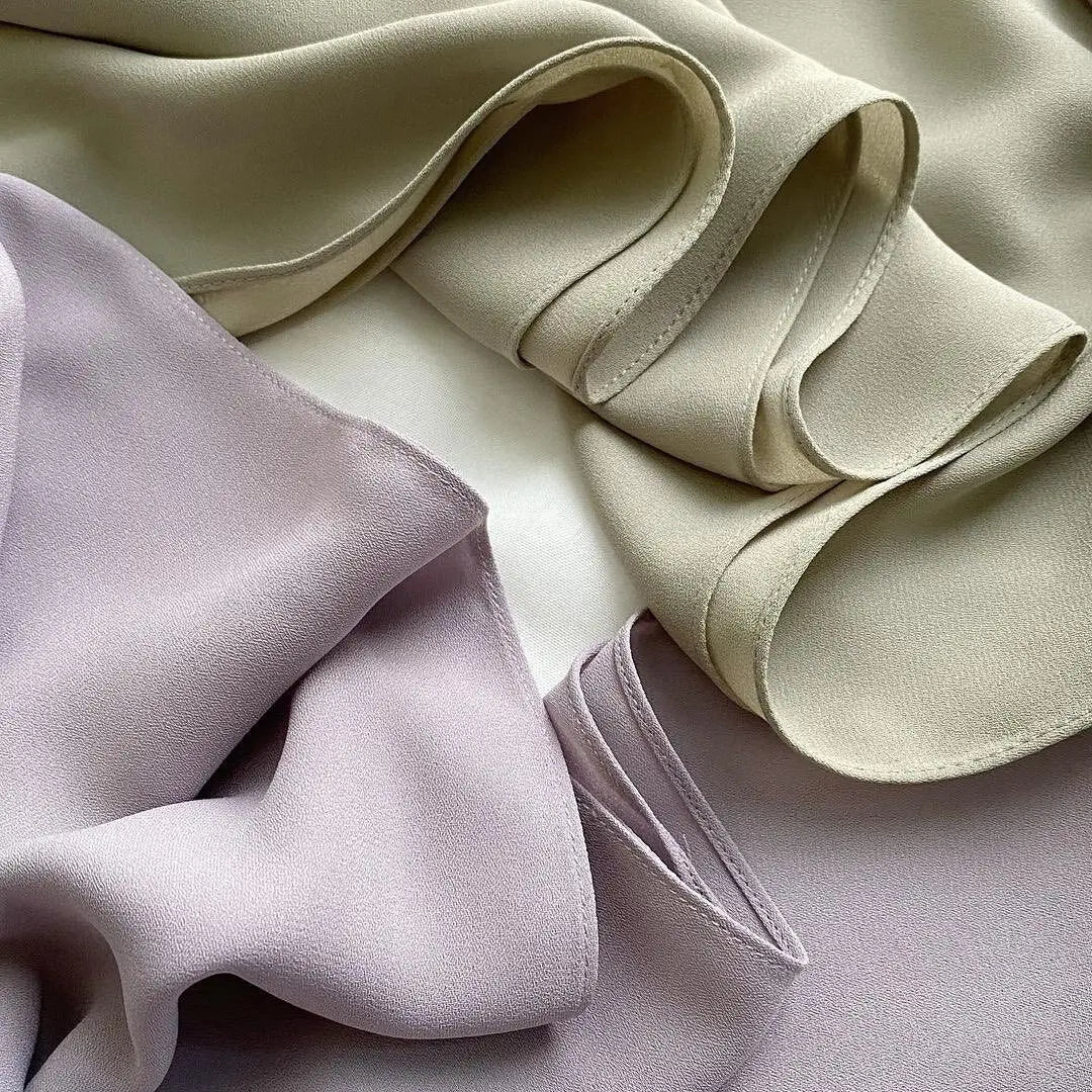 Nahaufnahme eines Premium-Hijab-Sets aus zartem Lila und Beige, das die drapierte Stoffqualität zeigt.