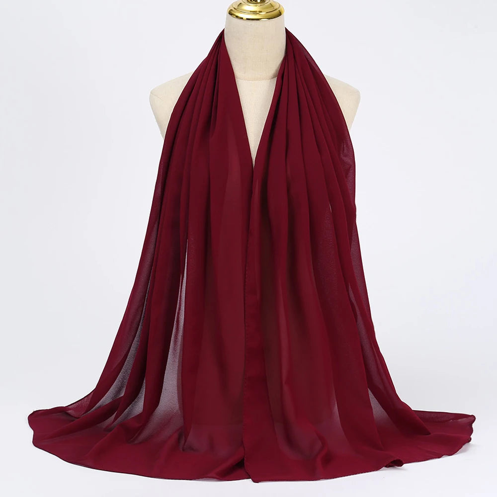 Ein tiefmaroniges Chiffon-Hijab-Schal, über eine Mannequin-Hals drapiert.