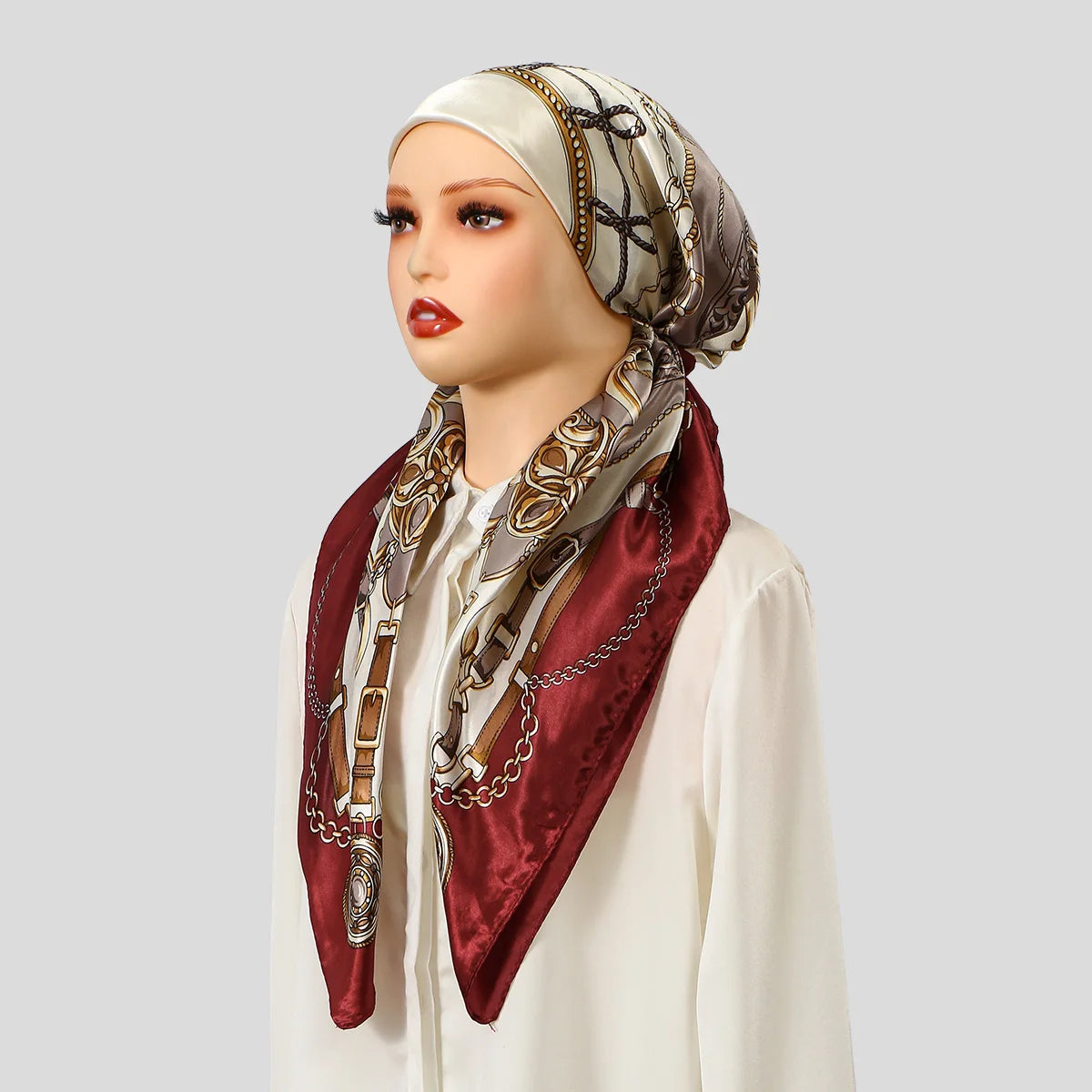 Eine Frau präsentiert einen satinbedruckten Instant-Hijab-Schal in Maroon- und Beige-Tönen als Kopftuch.