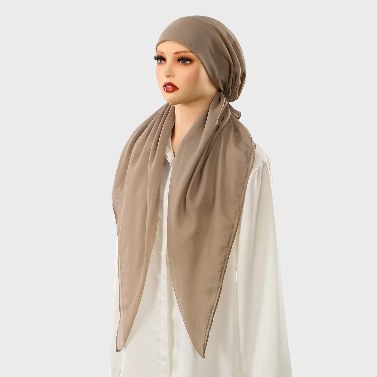 Une femme portant un foulard carré beige et un foulard assorti sur un haut blanc.