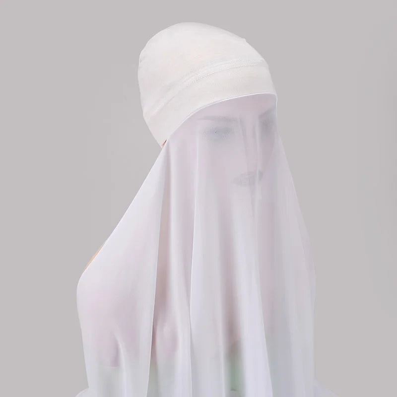 Pañuelo y chal de gasa blanca transparente exhibidos sobre un fondo gris claro.
