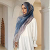 Eine Frau trägt einen dezenten Hijab-Schal aus Aquarell-Digitaldruck in Blau- und Grautönen.