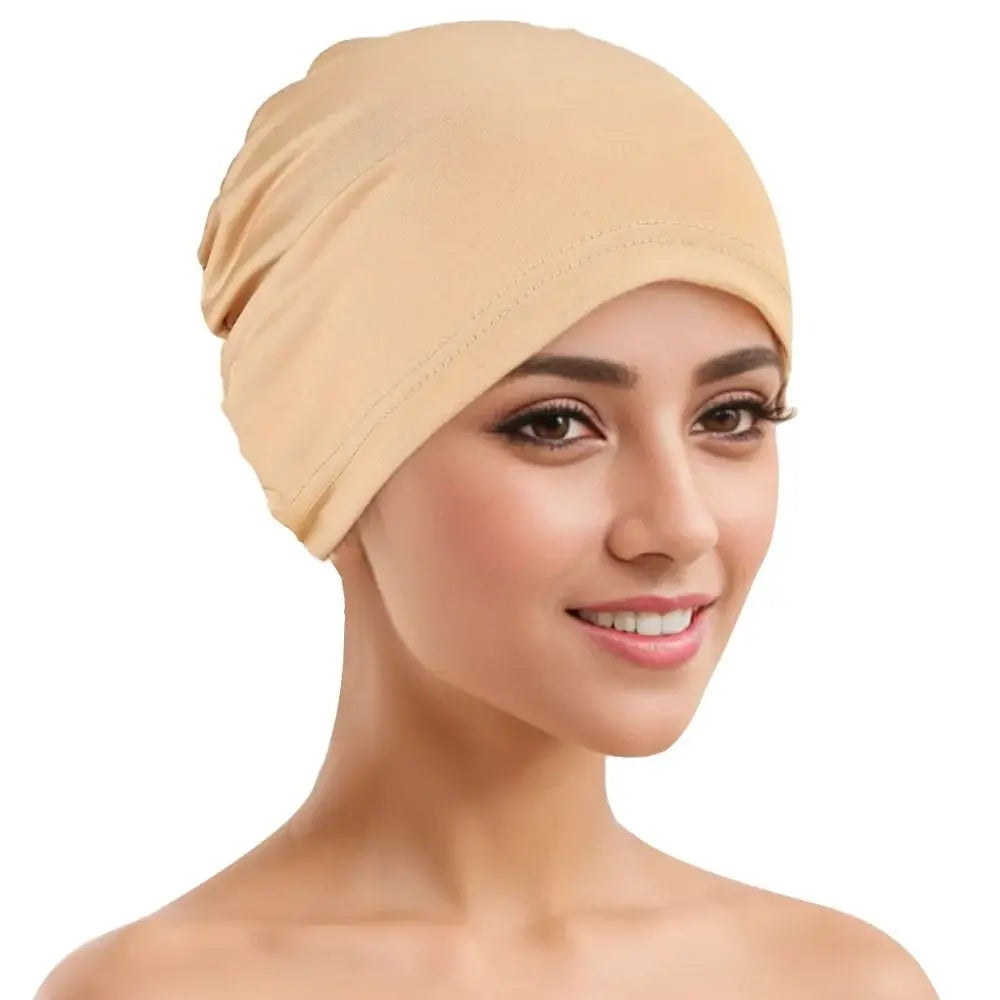 A woman wearing a beige breathable cotton underscarf with an elastic fit