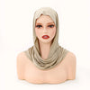 Ein Modell trägt einen beigeen Jersey-Hijabschal, der um ihren Kopf und Hals drapiert ist.