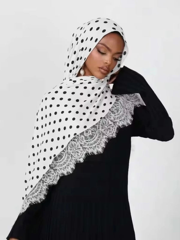 A woman wearing a black top and a white polka dot lace modal double-sided print hijab.