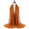 A draped orange chiffon hijab scarf displayed on a mannequin.