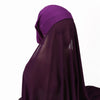 Un conjunto de hijab y chal de gasa instantánea morado usado por una persona.