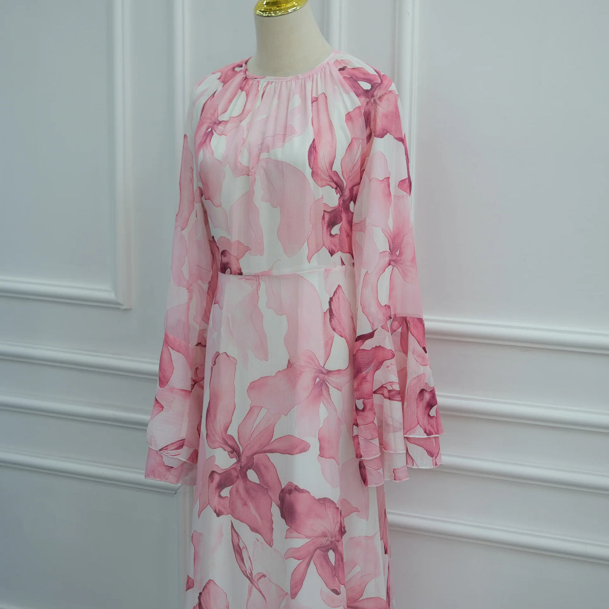 Langes, fließendes Abaya oder Kaftan-Kleid mit rosa-weißem Blumenmuster auf einem Mannequin.