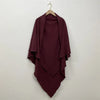 A deep burgundy two-layer everyday hijab scarf draped on a hanger against a white wall.