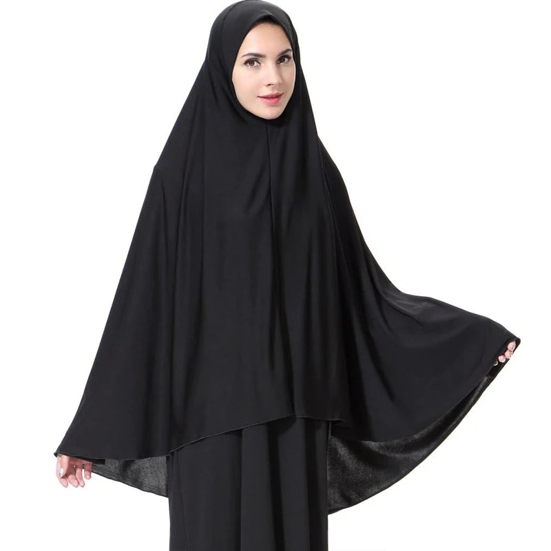 Una mujer vistiendo un elegante pañuelo hijab negro ligero para vestir modesta.