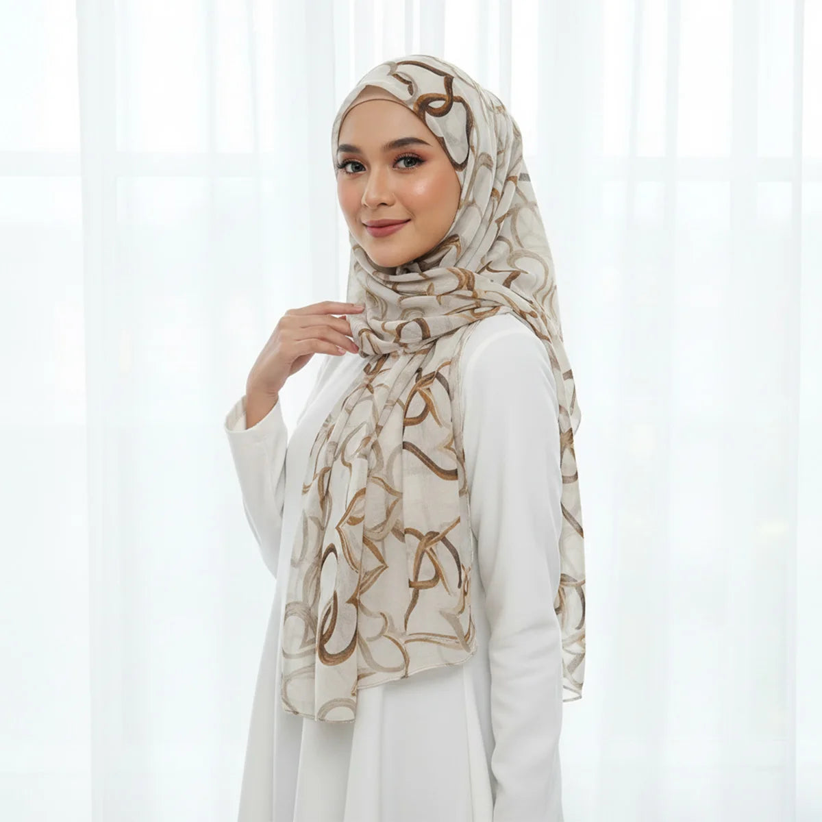 Eine Frau trägt einen eleganten floralen Seid-Hijabschal in beige- und braunen Tönen.