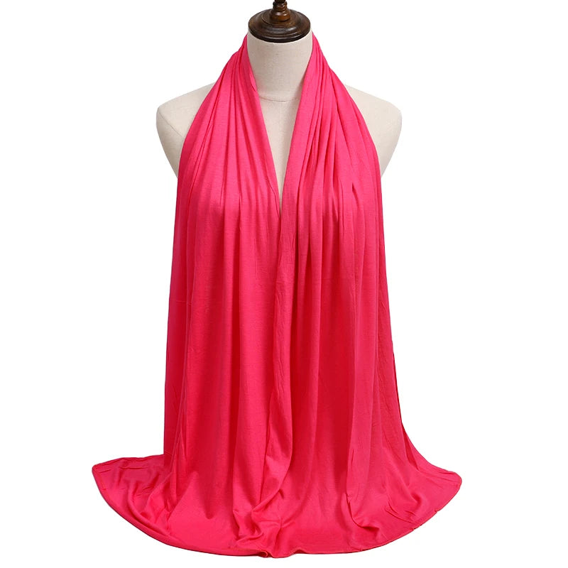A bright pink premium modal jersey hijab draped around a mannequin's neck.