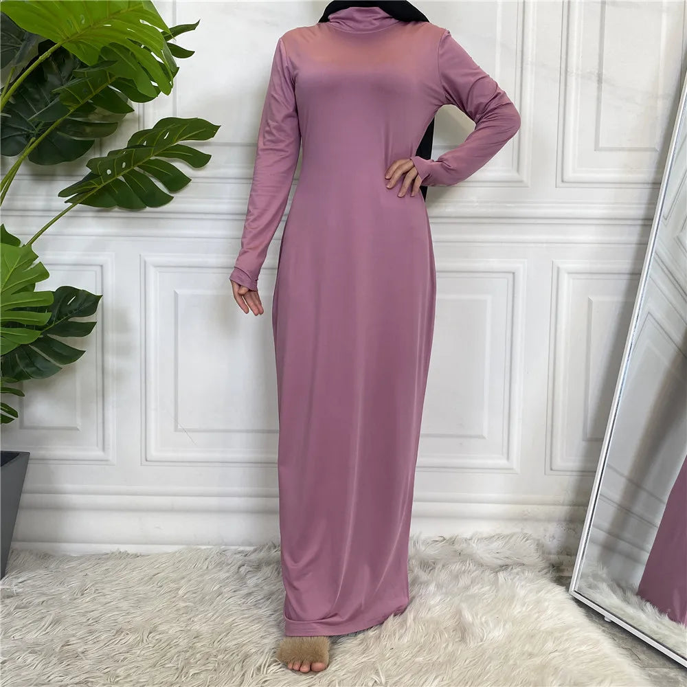 Langes, langärmeliges mauve Abaya-Kleid mit Rollkragen, präsentiert vor weiß verkleidetem Wand