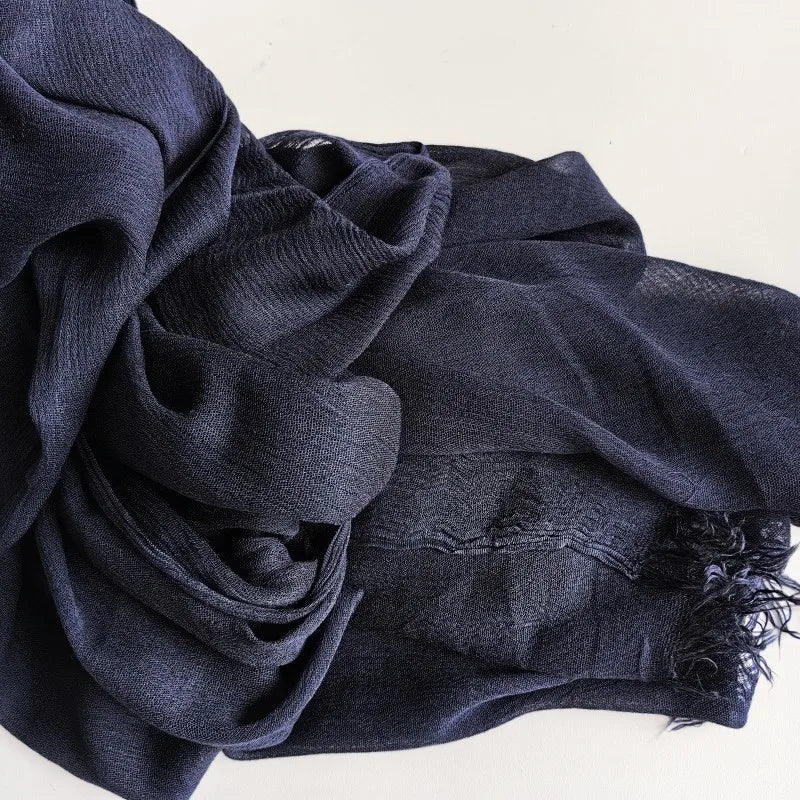 Foulard hijab en viscose coton gris foncé avec pompon drapé dans le tissu.