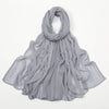 Écharpe châle en rayon gris clair, drapée et pliée élégamment.