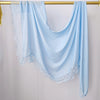 Hijab de gasa azul claro con estampado doble, drapeado sobre un percha dorada.