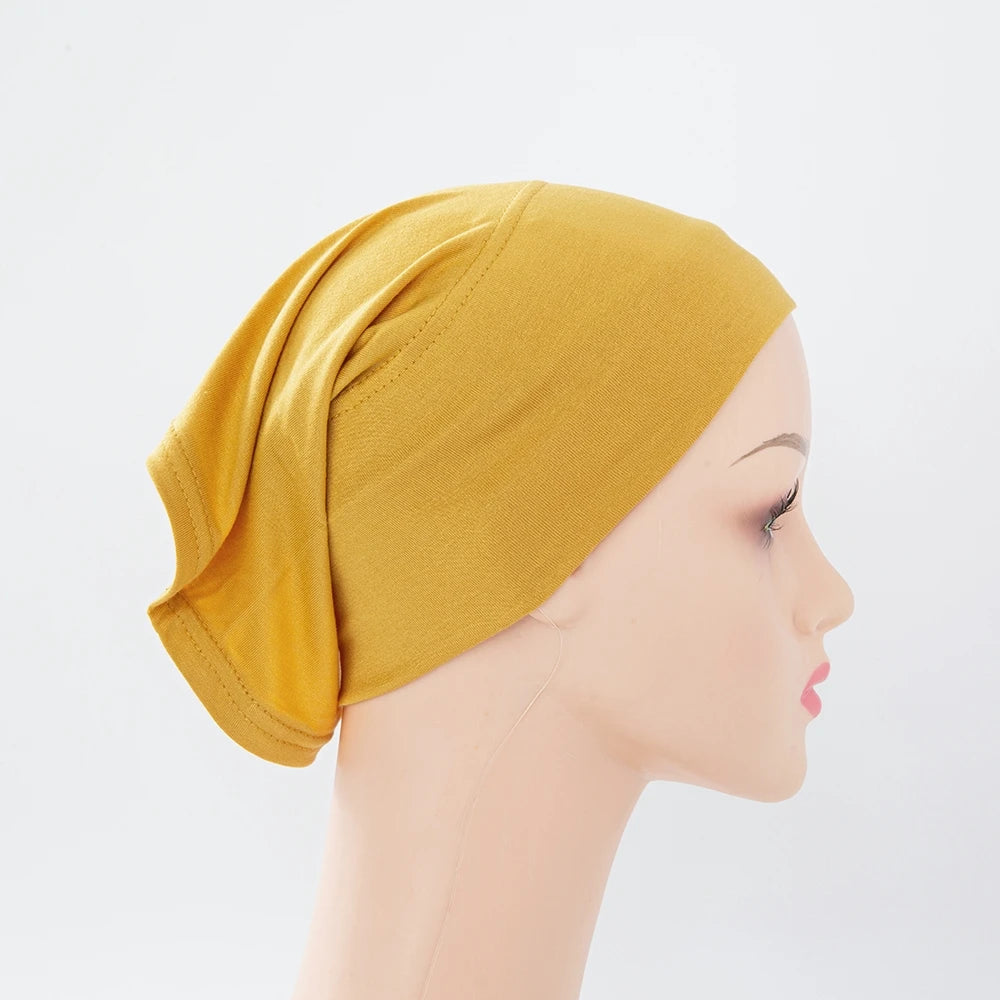 Senffarbener Bambus-Jersey-Turban-Cap auf einem Mannequin-Kopf.