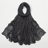 Écharpe châle crinklé en rayon gris foncé drapé sur fond blanc.