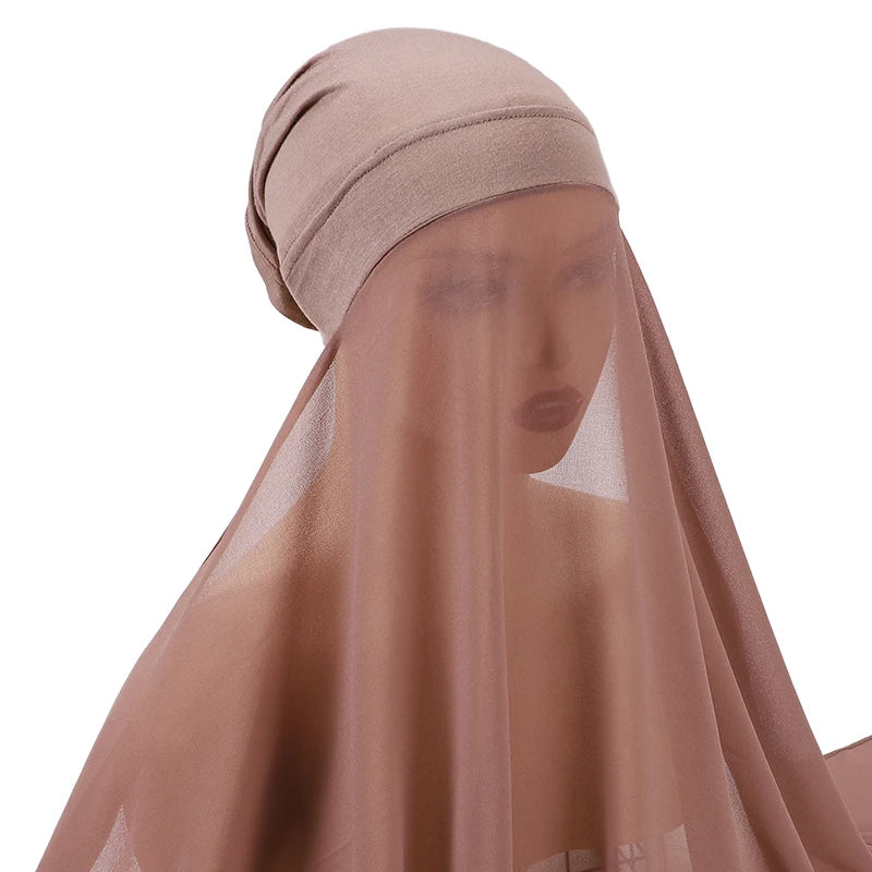Primer plano de un conjunto de hijab y chal de gasa de color nude usado por una modelo.