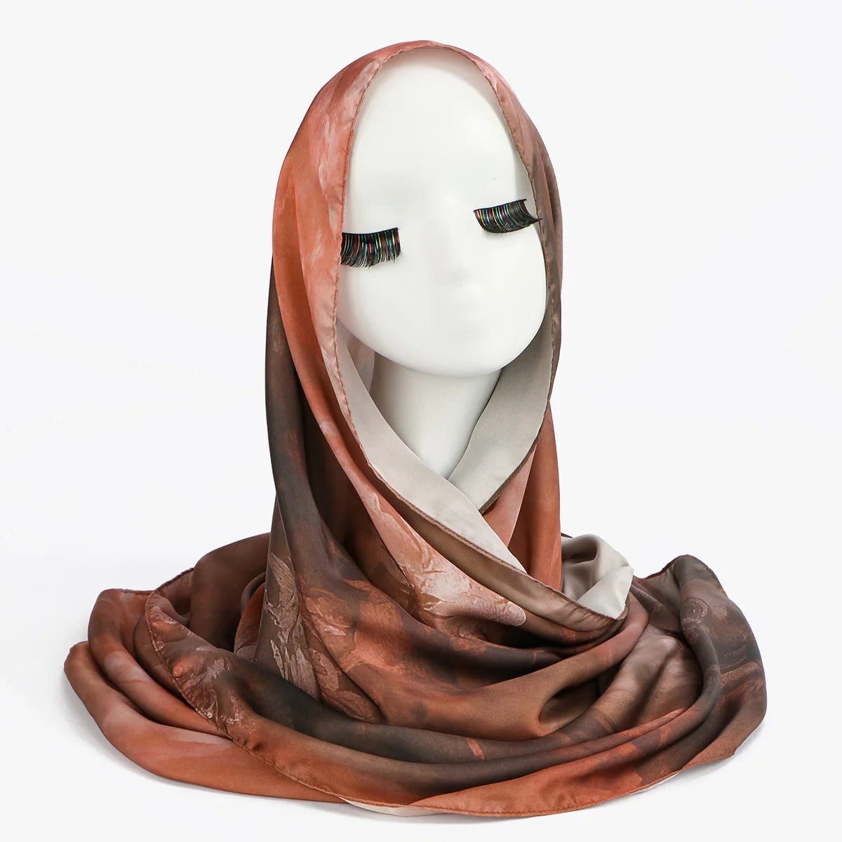 Verhülltes, rötlich-braunes Seiden-Schal, präsentiert auf einem weißen Mannequin-Kopf.