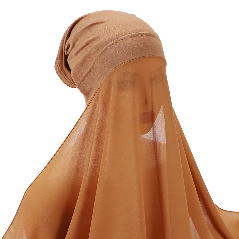 Primer plano de un hiyab y chal de chifón instantáneo beige puestos en la cabeza.