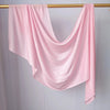 Foulard hijab rose uni drapé sur un cintre en bois.