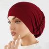 Nahaufnahme einer Frau mit einem tiefburgunderen Stretch-Turbanmütze.