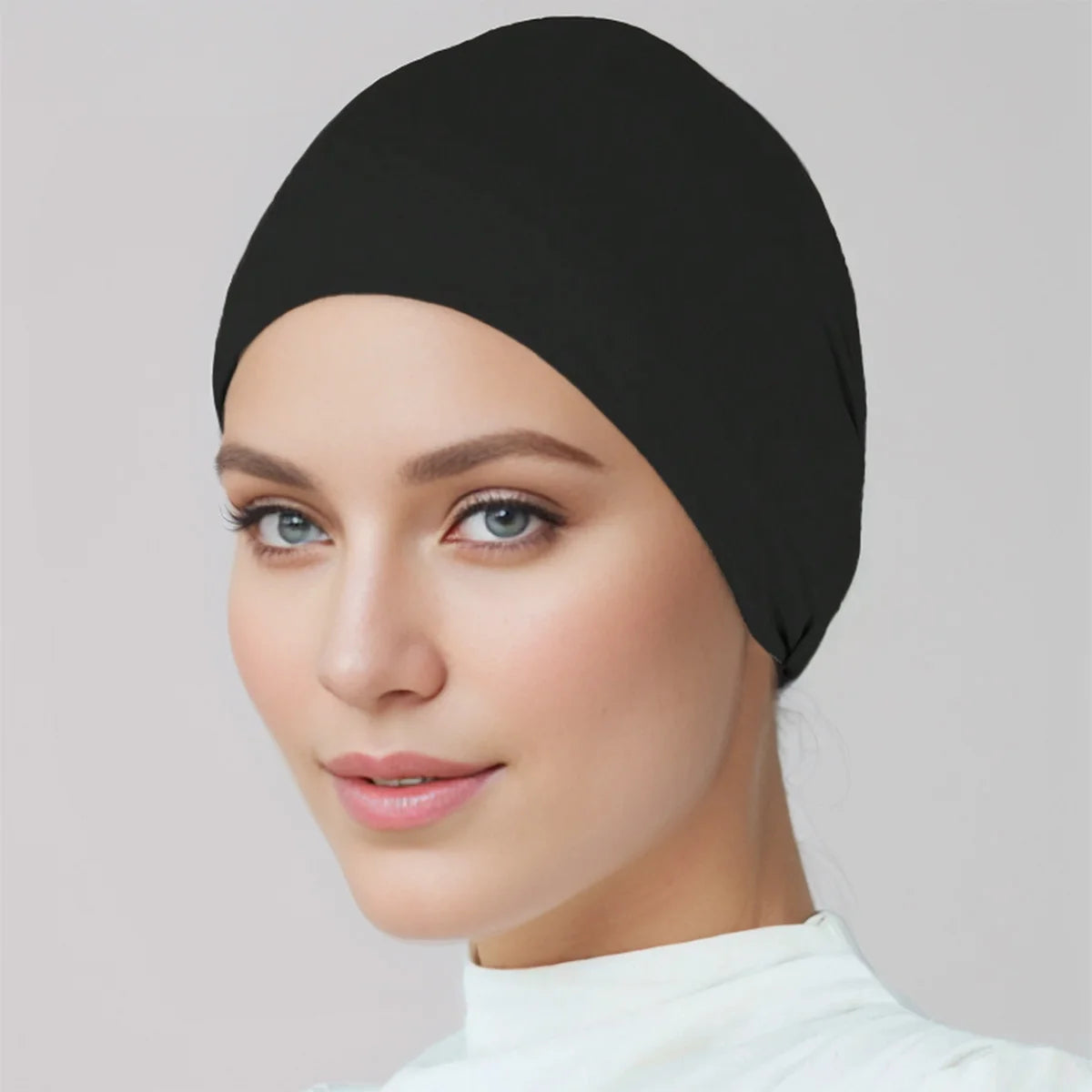 Eine Frau trägt eine schwarze Premium-Stretch-Baumwoll-Hijab-Underscarf-Kappe.