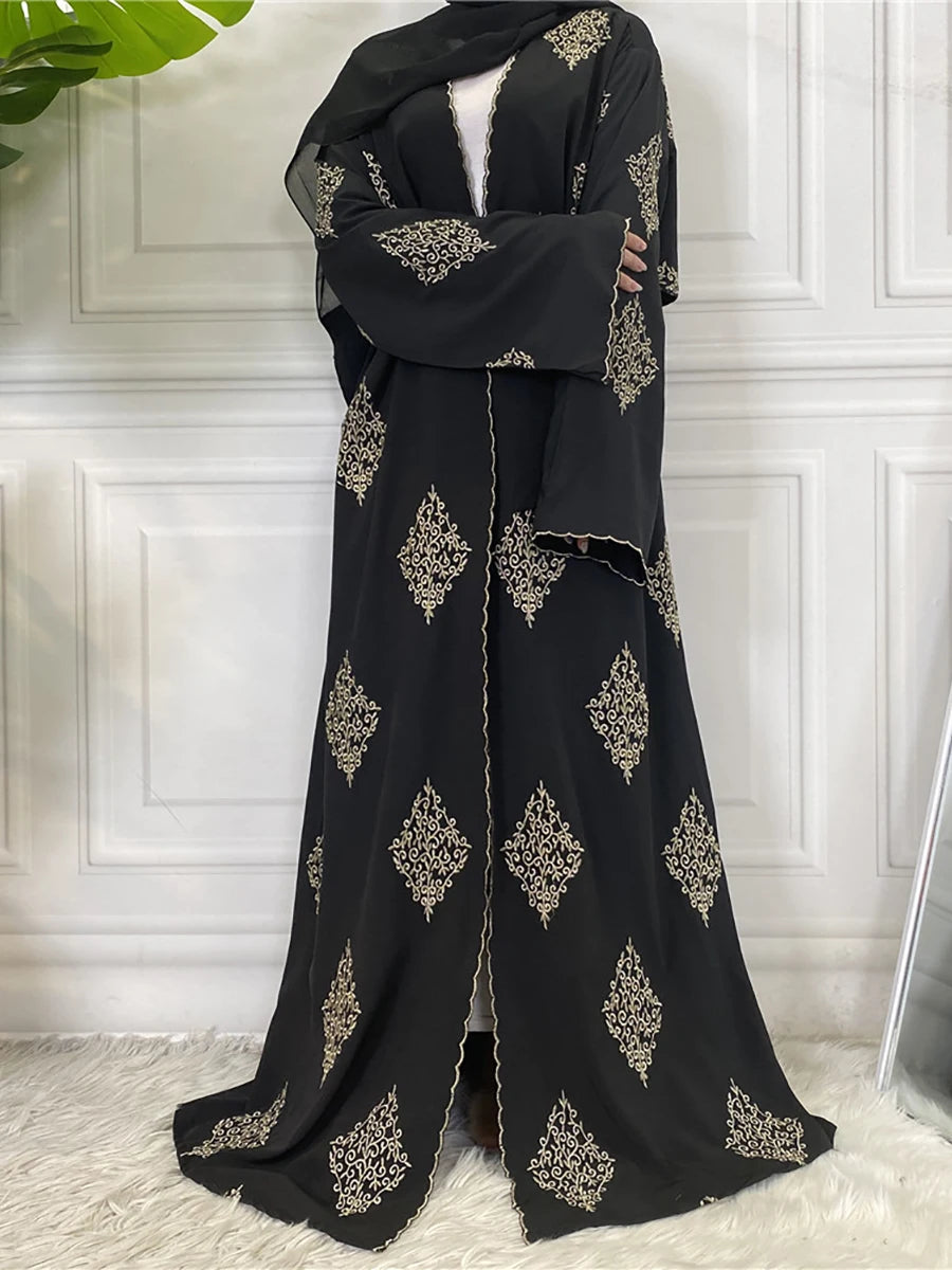 Abaya kaftan islamique noire élégante avec broderie dorée sur fond blanc.