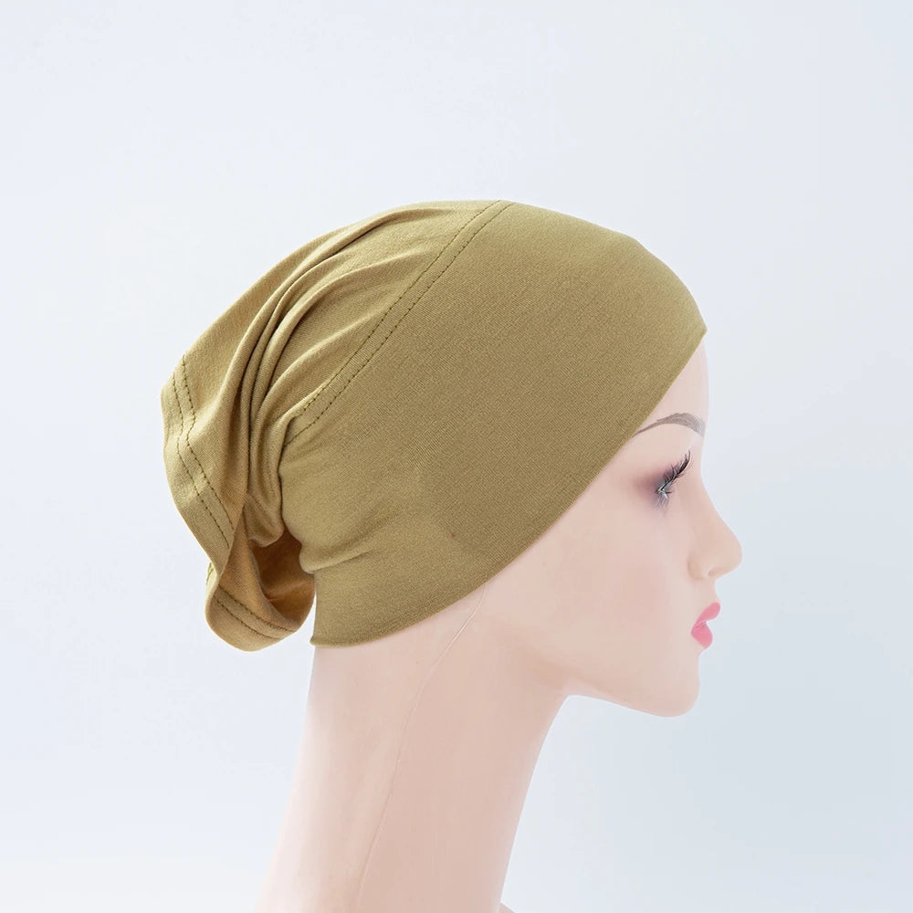 Nahaufnahme einer olivgrünen Bambus-Jersey-Turban-Kappe auf einem Mannequin.
