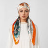 Eine Frau modelliert einen orange-weißen Seiden-Instant-Hijab-Schal, der um ihren Hals drapiert ist.