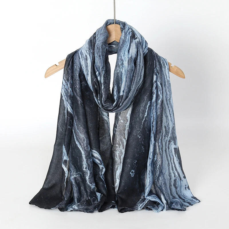 Pañuelo de hijab de acuarela gris oscuro y blanco sobre un percha de madera.