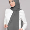 A woman wearing a gray chiffon matching inner scarf set with a white top.