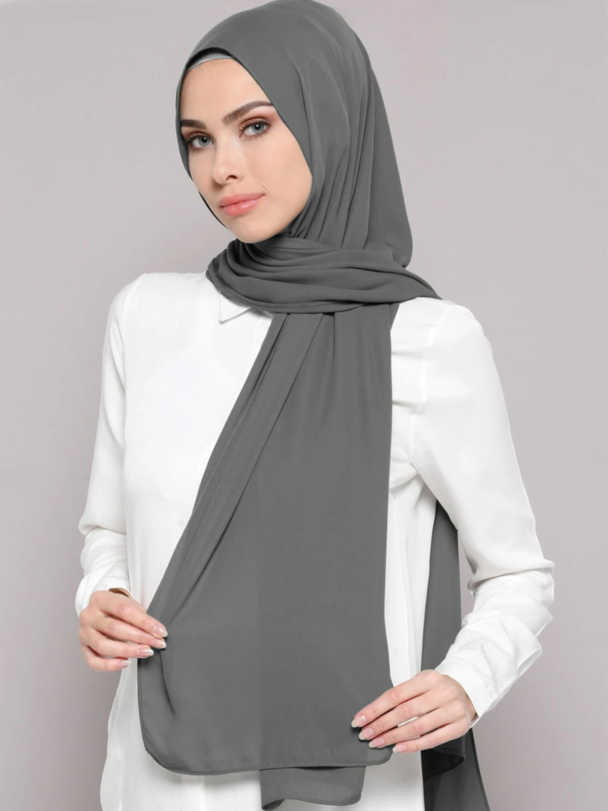 A woman wearing a gray chiffon matching inner scarf set with a white top.