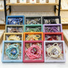 A display of Islamic tasbih prayer beads and digital counter bracelets in various colors and materials.