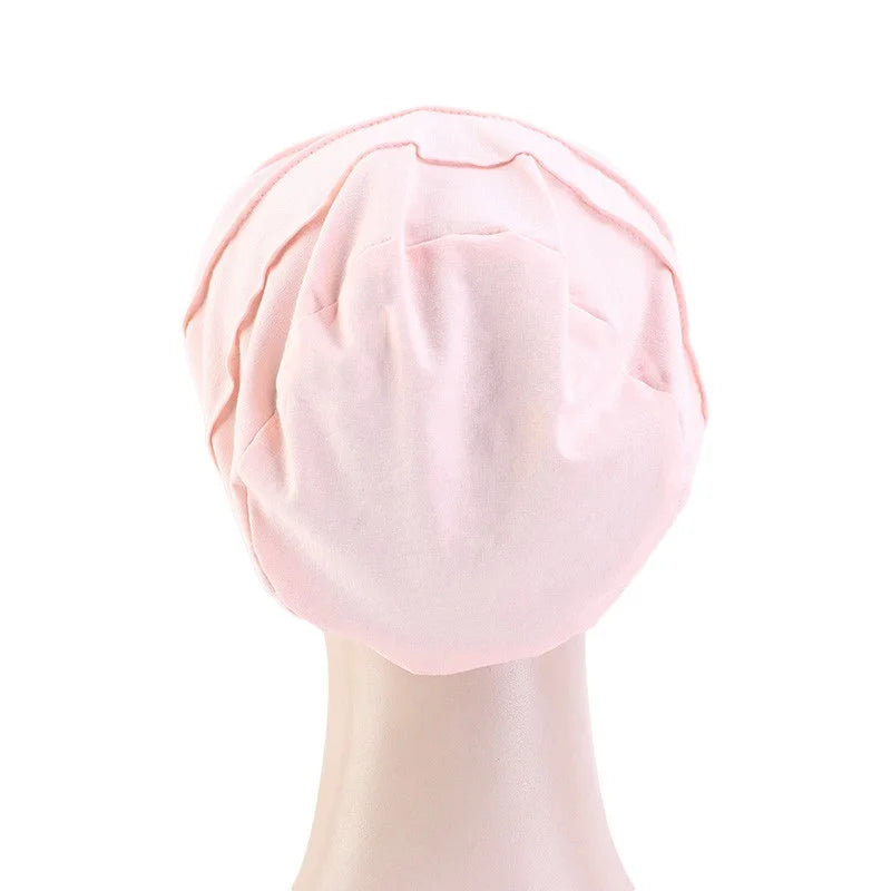 Pinkes Stretch-Baumwoll-Beanie-Turban-Hut mit Satinfutter auf einem Mannequin-Kopf