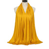 Pañuelo de algodón modal amarillo mostaza fluido drapeado alrededor del cuello de un maniquí.