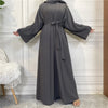 A full-length, charcoal gray elegant women's abaya and kaftan set displayed against a white paneled wall.