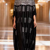 Model trägt ein schwarzes, mit schweren Pailletten besticktes Batwing-Robe-Kleid auf der Runway.