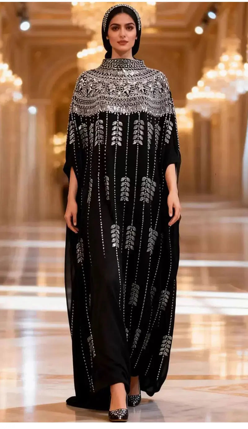Model trägt ein schwarzes, mit schweren Pailletten besticktes Batwing-Robe-Kleid auf der Runway.
