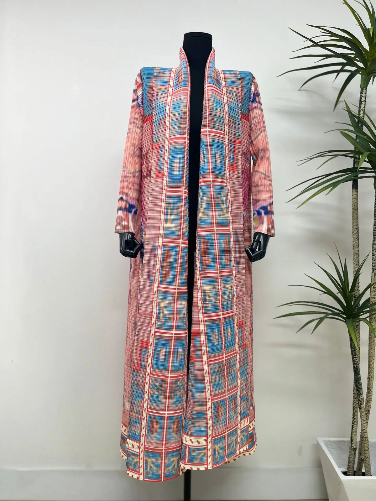 Langes rosa und blaues kariertes Abaya-Cardigan auf einem schwarzen Mannequin.